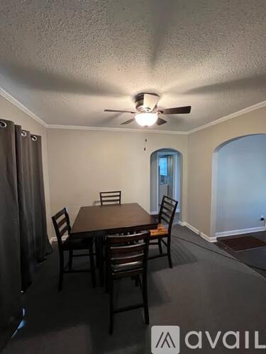 A dining room with a table and chairs.