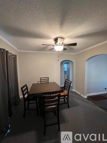 A dining room with a table and chairs.