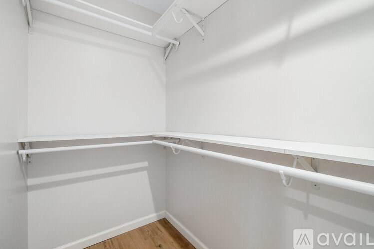 A white room with a long white shelf and a white ceiling fan.