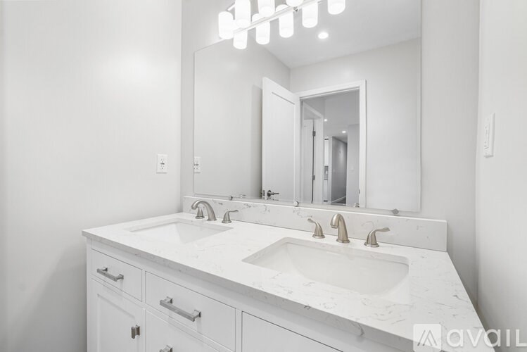 A white bathroom vanity with a large mirror above it.