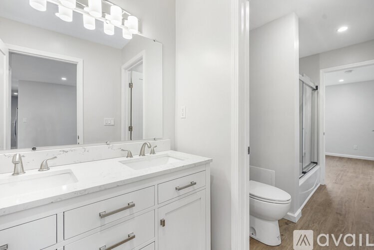 A bathroom with a white counter top and a white toilet.