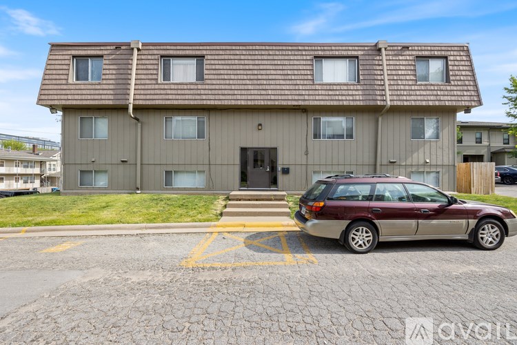 A brown house with a car parked in front.