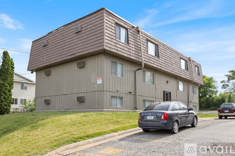 A grey building with a car parked in front of it.