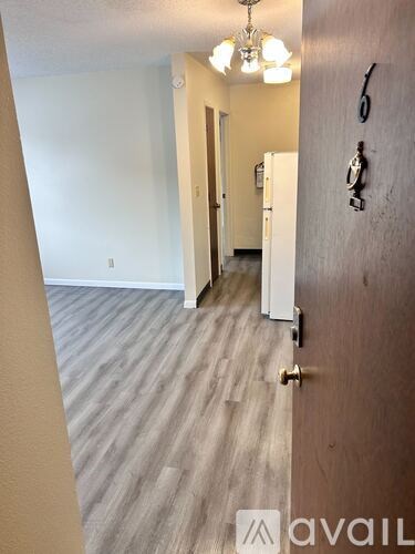 A hallway with a white door and a wall with a clock on it.