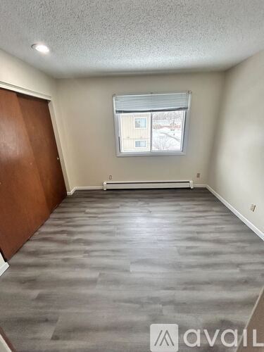 A room with a window and a wooden door.