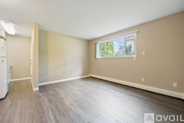 A room with a window and a wooden floor.