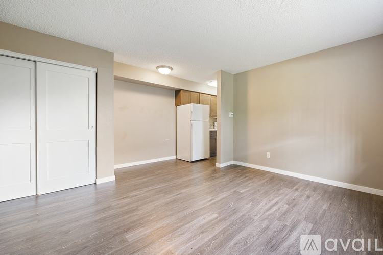 A room with a white door and a wooden floor.