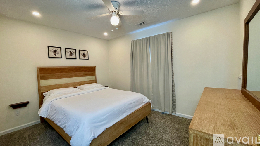 A bedroom with a bed, a dresser, and a mirror.
