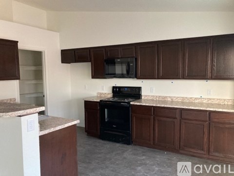 A kitchen with brown cabinets and a black oven.