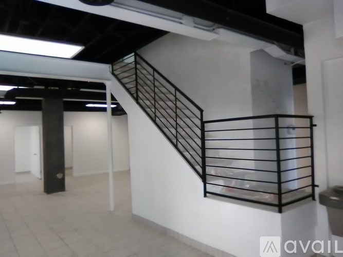 A staircase with a metal railing and a black pole.