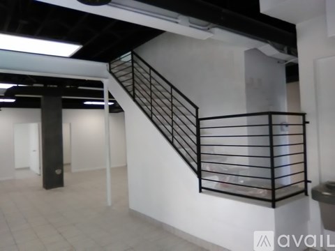 A staircase with a metal railing and a black pole.