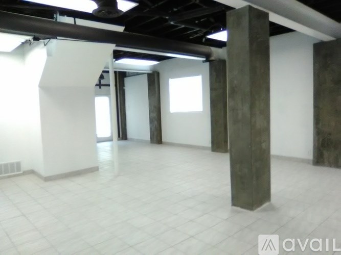 A large empty room with white walls and a tiled floor.