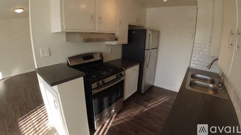 A kitchen with white cabinets and a black countertop.