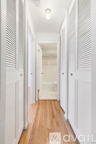 A long hallway with white walls and wood floors.