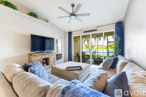 A living room with a large couch and a television on a stand.