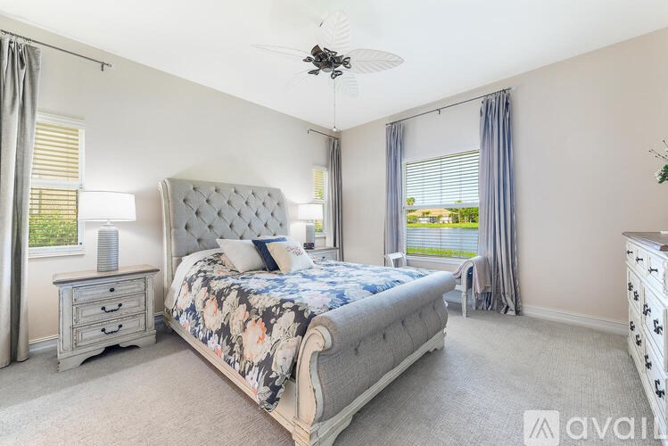 A bedroom with a large bed, a dresser, and a ceiling fan.