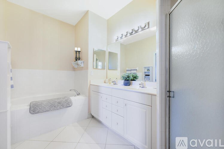 A bathroom with a white tub, sink, and vanity.