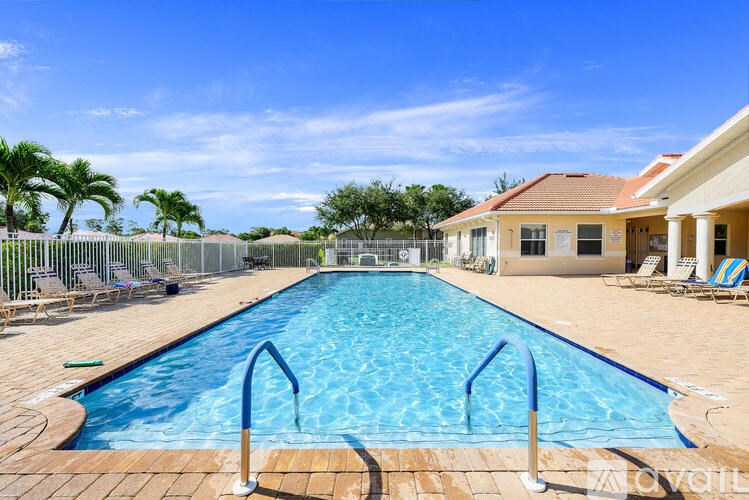 A large outdoor swimming pool with a blue tiled edge and a metal ladder.