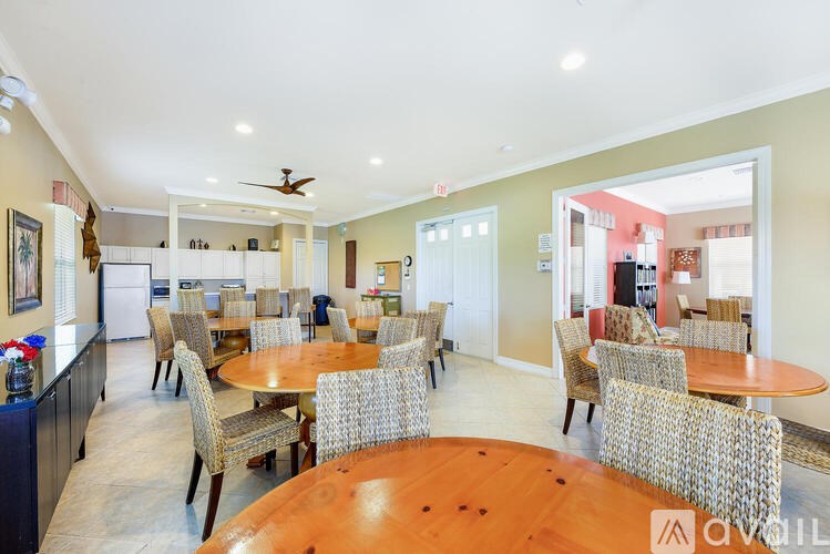A dining room with a wooden table surrounded by chairs.