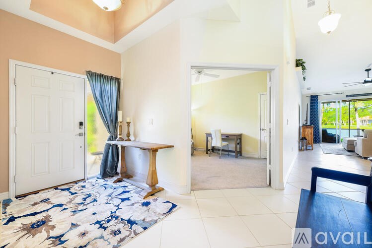 A living room with a white door and a blue floral rug.