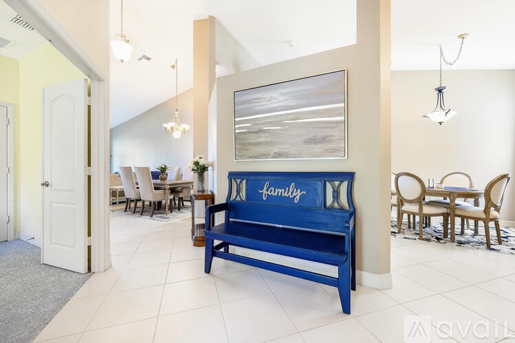 A blue bench with the word family written on it is in the middle of a room.