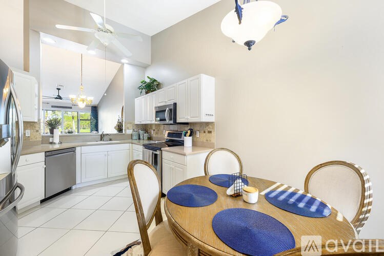 A kitchen with a table set for two with blue placemats.