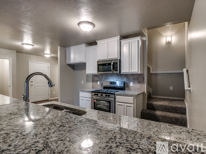 A kitchen with granite countertops and white cabinets.