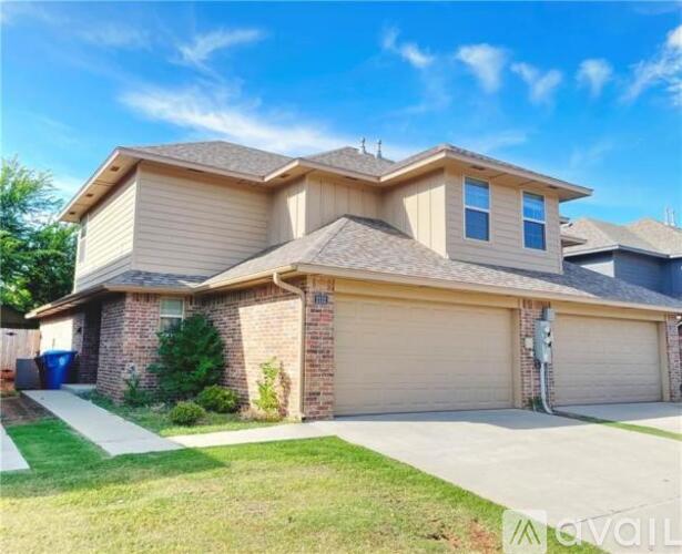 A two-story house with a garage and a driveway.