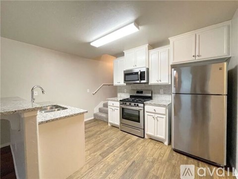 A kitchen with white cabinets and stainless steel appliances.