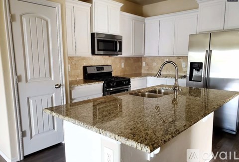 A kitchen with granite countertops and stainless steel appliances.