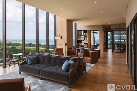 A living room with a large couch and a view of the ocean.