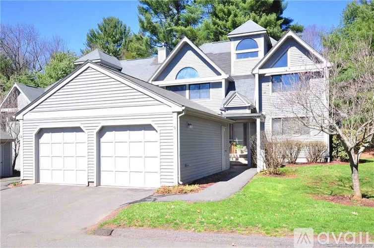 A house with a grey roof and two garage doors.