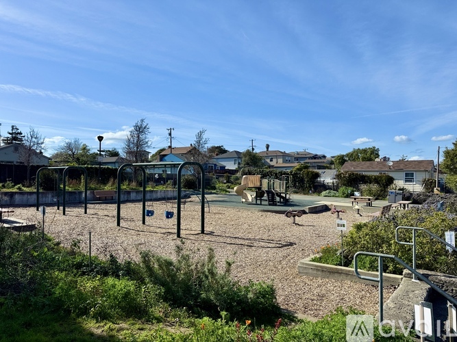 A playground with a swing set and a basketball hoop.