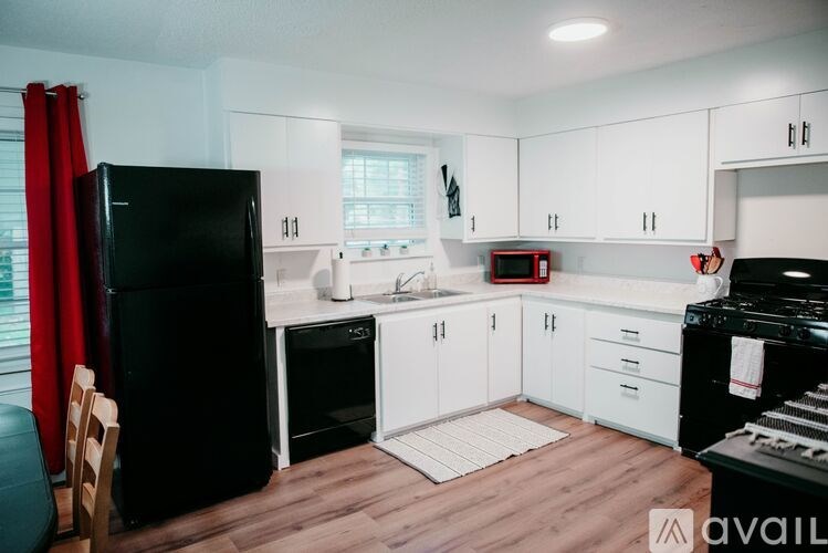 A kitchen with black appliances and white cabinets.