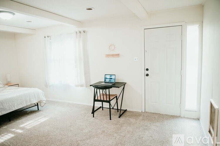 A room with a bed, desk, and chair.