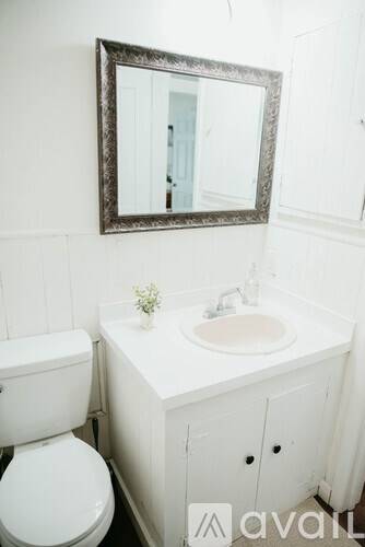A white toilet sits next to a sink in a bathroom.