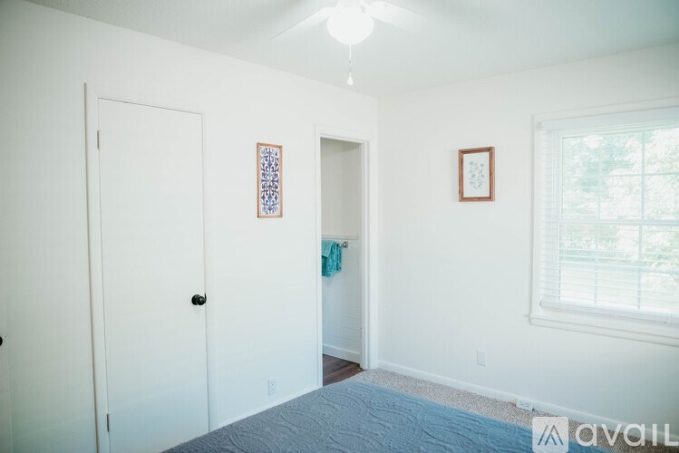 A bedroom with a bed, two doors, and a window.