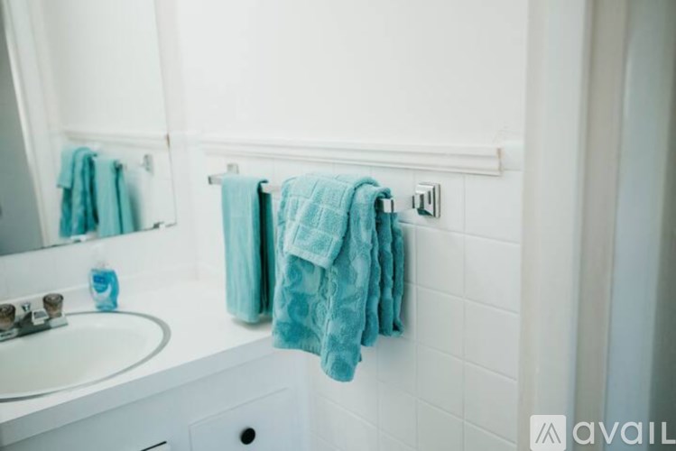 A white bathroom with a white sink and a white tiled wall.