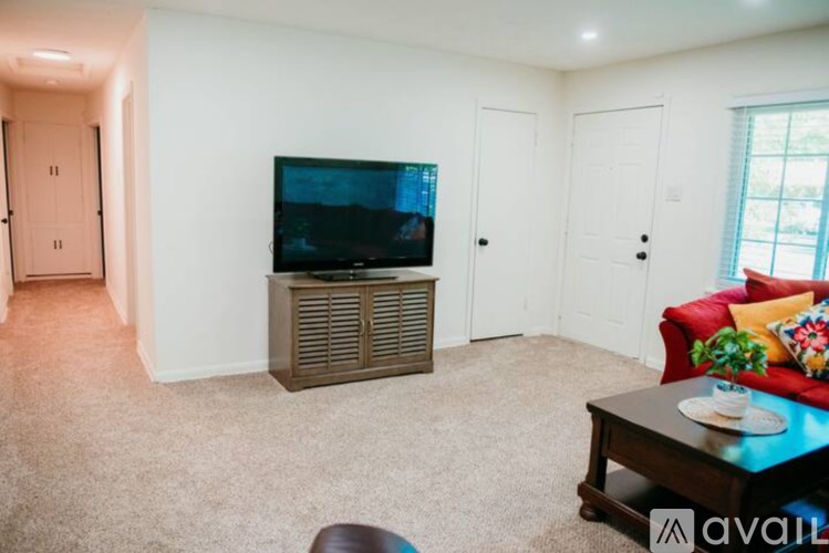 A living room with a television, a red couch, and a coffee table.