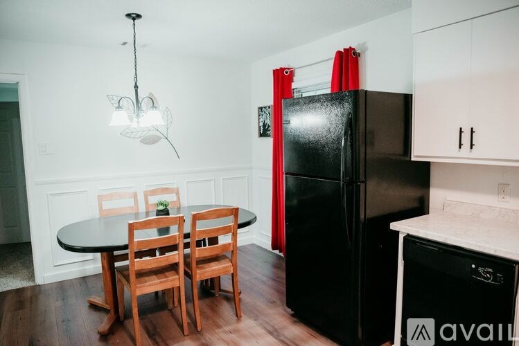 A kitchen with a black fridge and white cabinets.