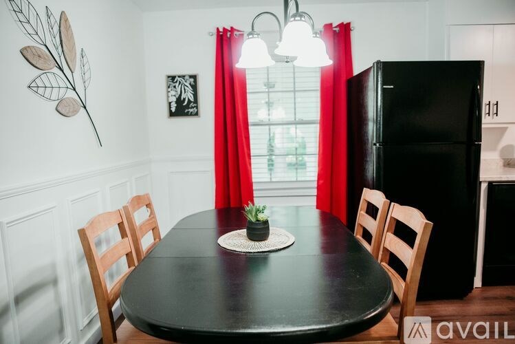 A black table with a plant on it and chairs around it.