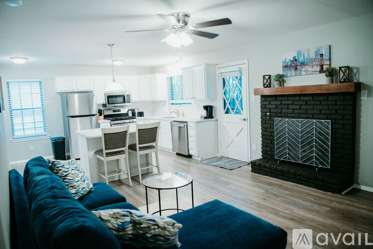 A living room with a blue couch and a fireplace.