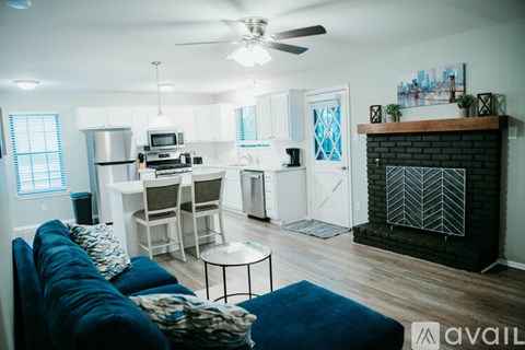 A living room with a blue couch and a fireplace.