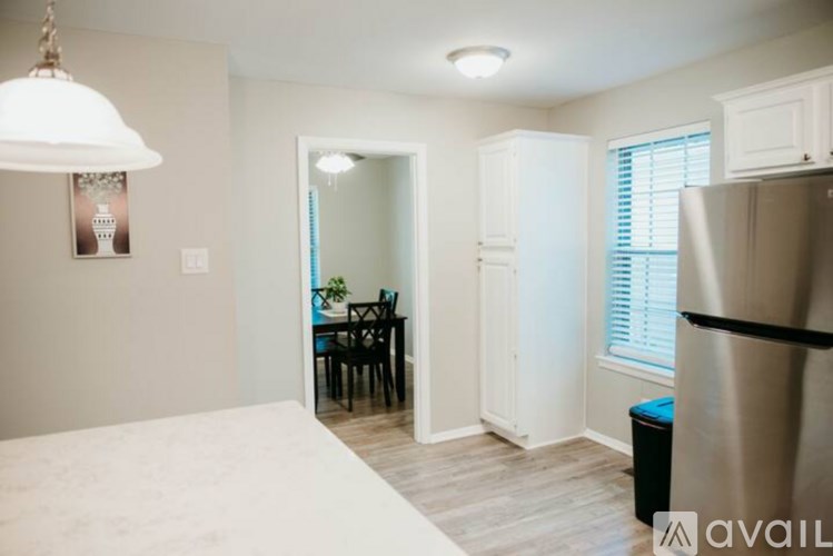 A kitchen with a refrigerator, table and chairs.
