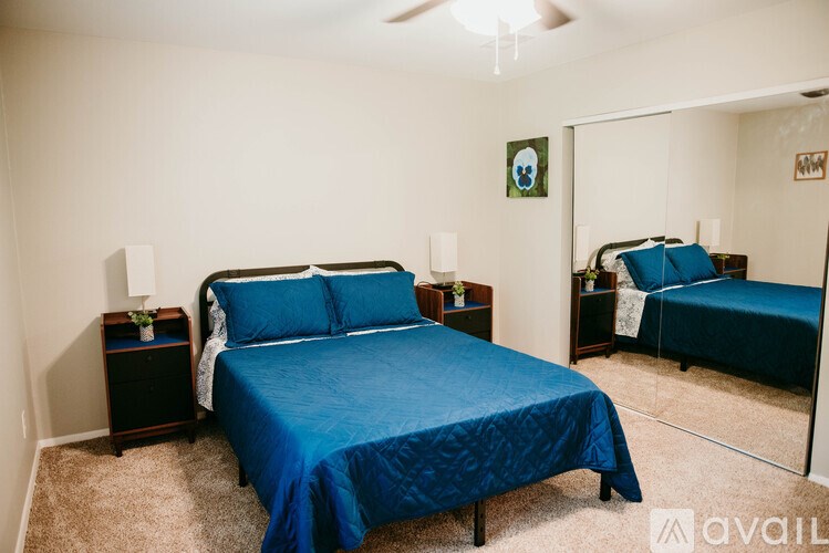 A bedroom with a blue bedspread and a bed with a blue cover.