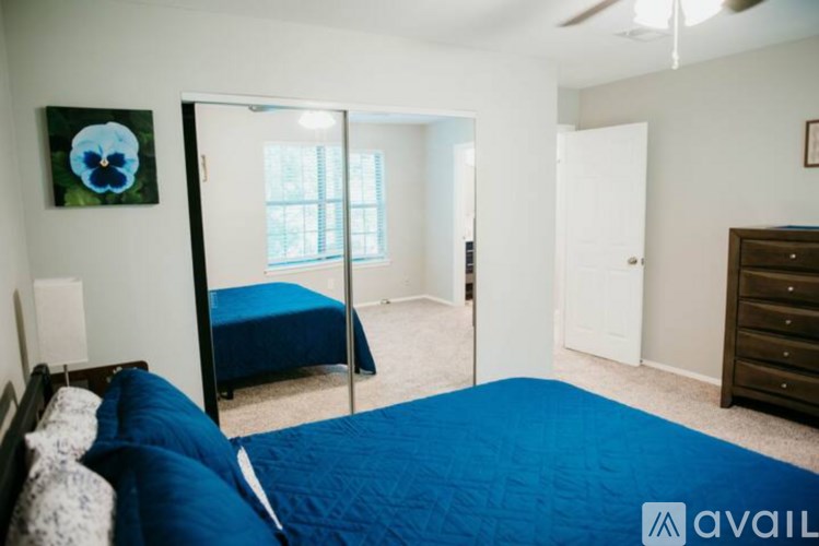 A bedroom with a blue bedspread and a blue bed.