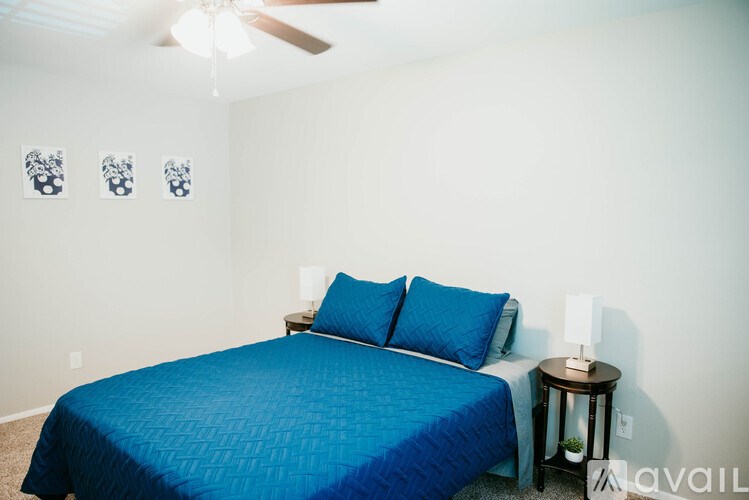 A bedroom with a blue bedspread and two blue pillows.