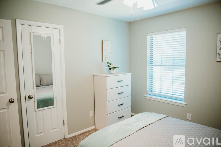 A bedroom with a bed, dresser, and mirror.