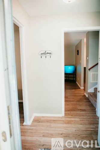 A hallway with a wall decal that says "welcome" and a door on the left.