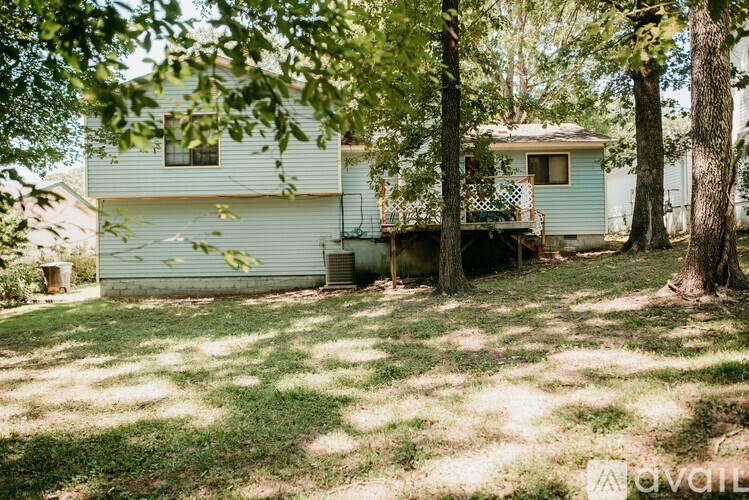 A house with a porch and a tree in front of it.